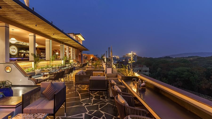 A night view of the terrace with ambient lighting, comfortable lounge areas, and a serene atmosphere.