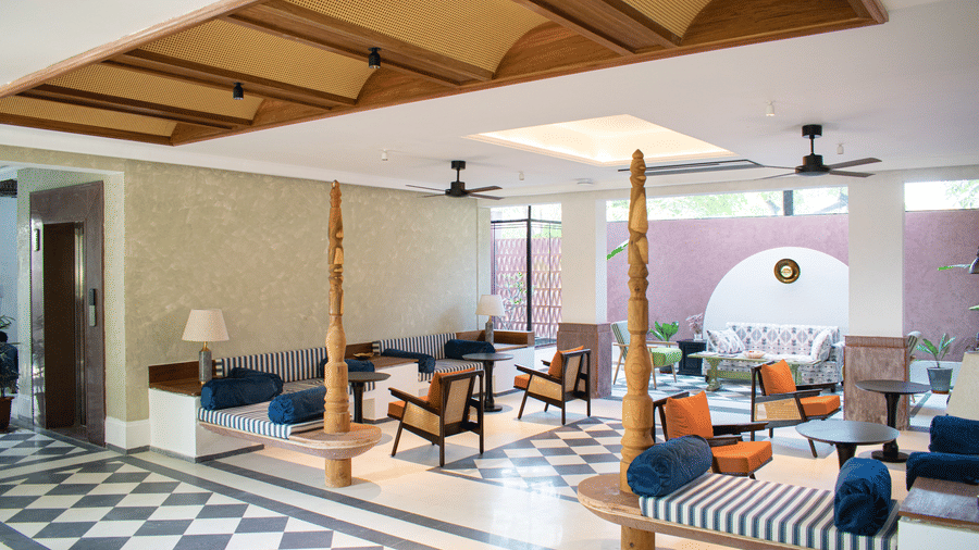 A spacious lobby with geometric floor patterns, traditional wooden accents, and a mix of contemporary and classic seating at The Sierra, Udaipur.
