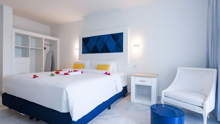 a king size bed and a white sofa on the right side of the bed - The Soco House