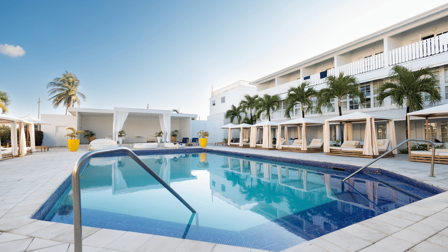 A side angle view of the pool with The Soco House's facade and the lounge space at the backdrop.