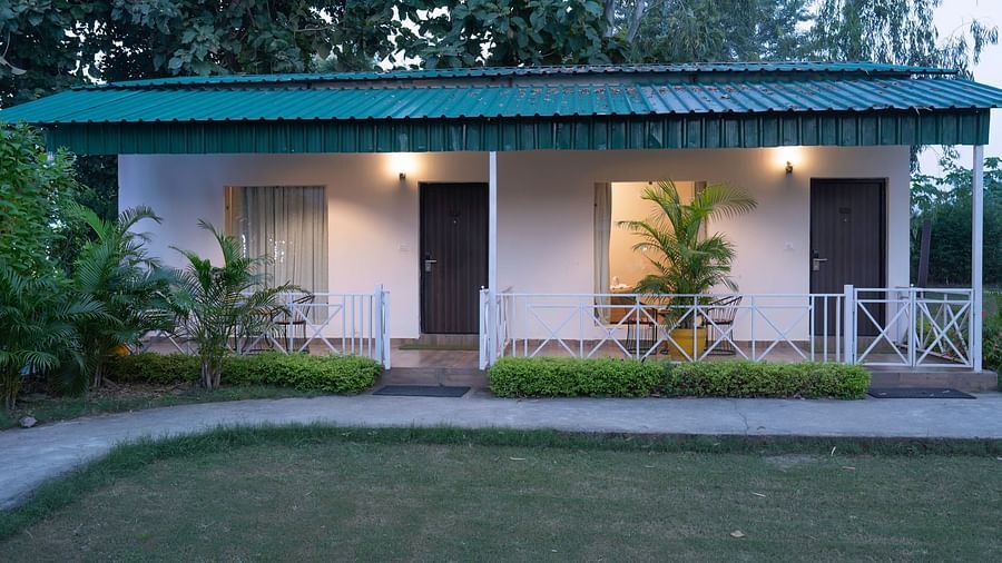 Lawn view cottages with private seating at The Tattwaa Corbett Spa & Resort.
