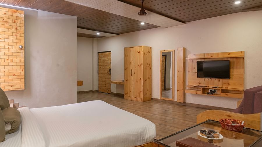 Cosy bedroom with sitting area and king bed at The Tattwaa Corbett Spa & Resort.