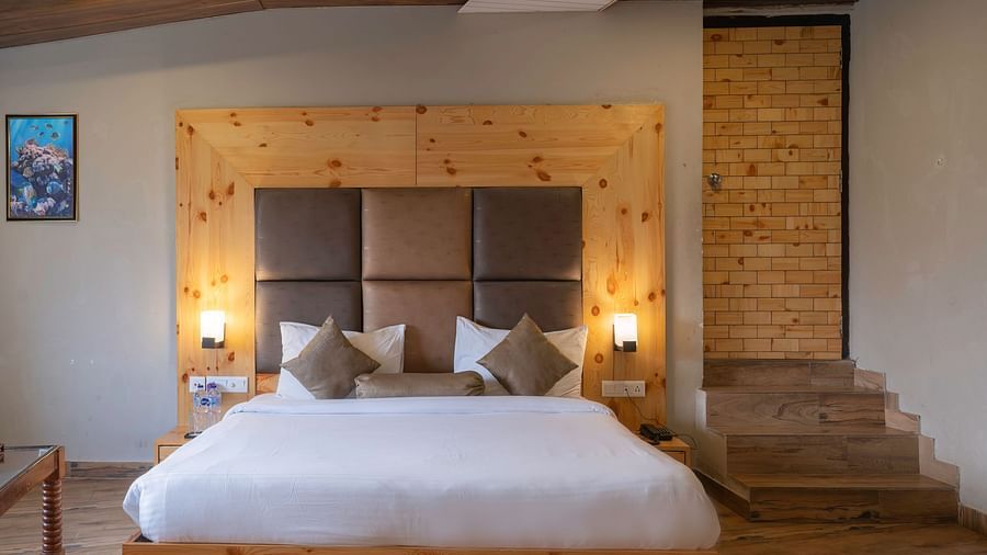 King-size bed in a warm, inviting room at The Tattwaa Corbett Spa & Resort.