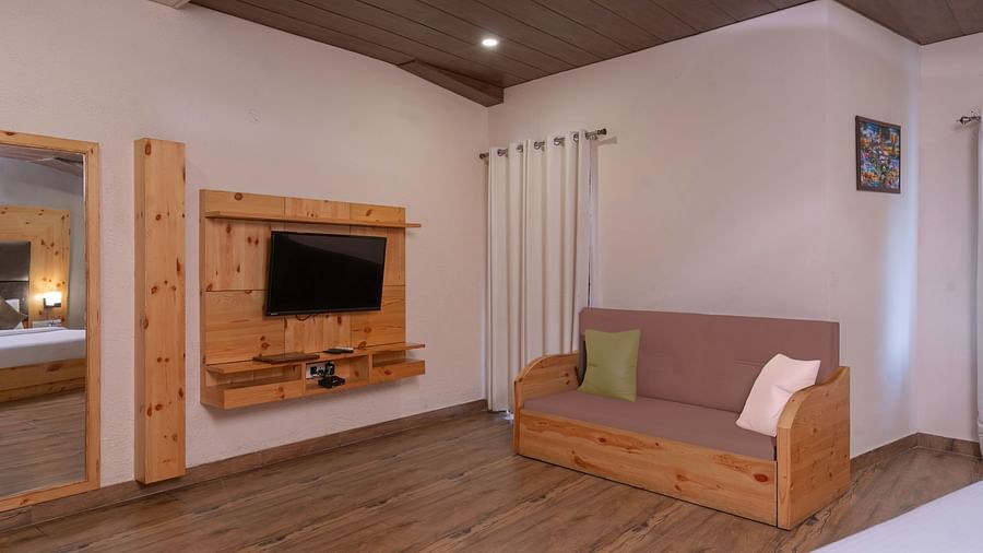 Sitting area at The Tattwaa Corbett Spa & Resort with a sofa and wooden flooring.