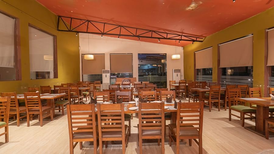 Bright and welcoming restaurant with wooden chairs at The Tattwaa Corbett Spa & Resort.