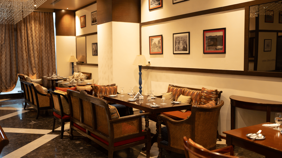 Elegant dining room with wooden chairs and framed artwork at Zaal Lounge & Kitchen, Whitefield