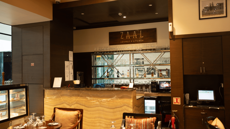 Fine dining interior with bar display and wooden furniture at Zaal Lounge & Kitchen, Whitefield Bengaluru