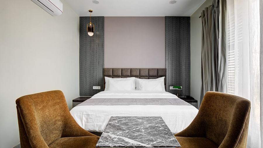 Grey themed Deluxe room room with chairs and a table - The White Moon