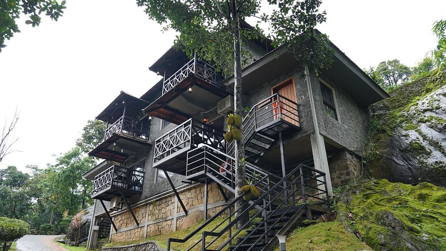 The exterior of a multi-level building with balconies, blending into a green, natural environment. | Premium Forest view 2 Bedroom Interconnecting Suite Cottage with Balcony | The Wild Trails Munnar