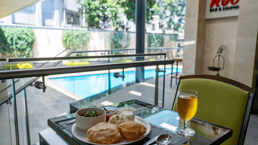 A breakfast tray with snacks and a chilled drink served by the pool at The Zehneria, Nairobi