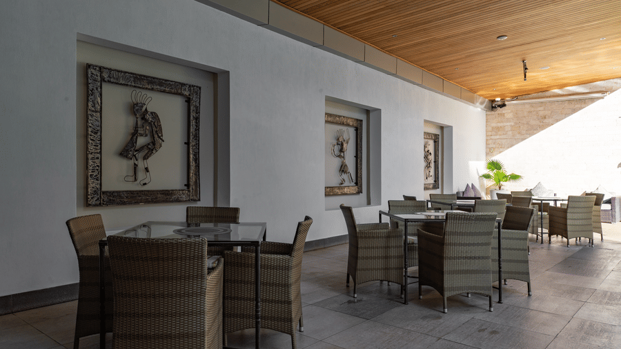 The covered swimming pool area featuring dining tables at The Zehneria, Nairobi.