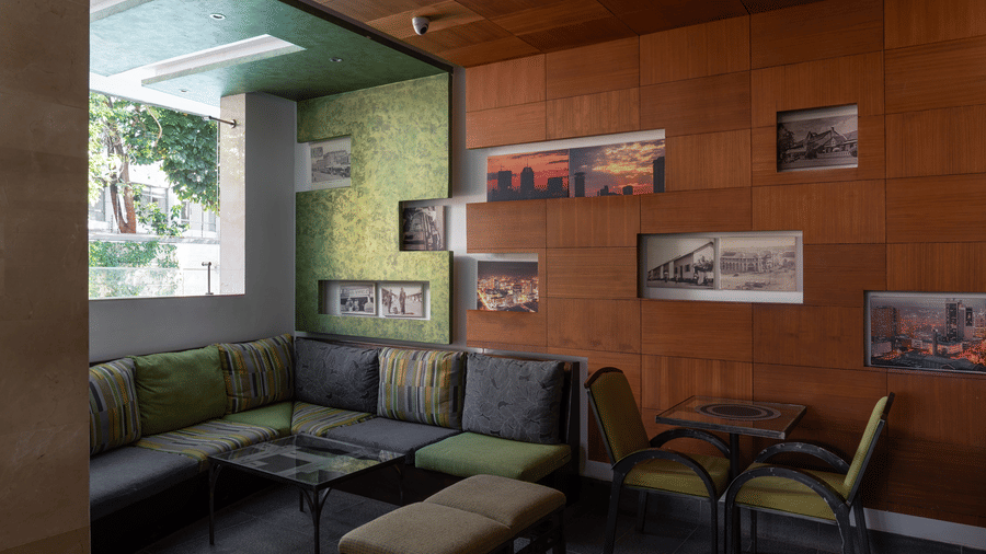 The cosy NBO bar seating area with sofa and wooden wall decor | The Zehneria, Nairobi.