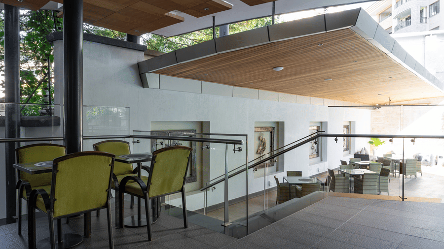 The outdoor seating area at NBO bar featuring stairs and natural lighting | The Zehneria, Nairobi.