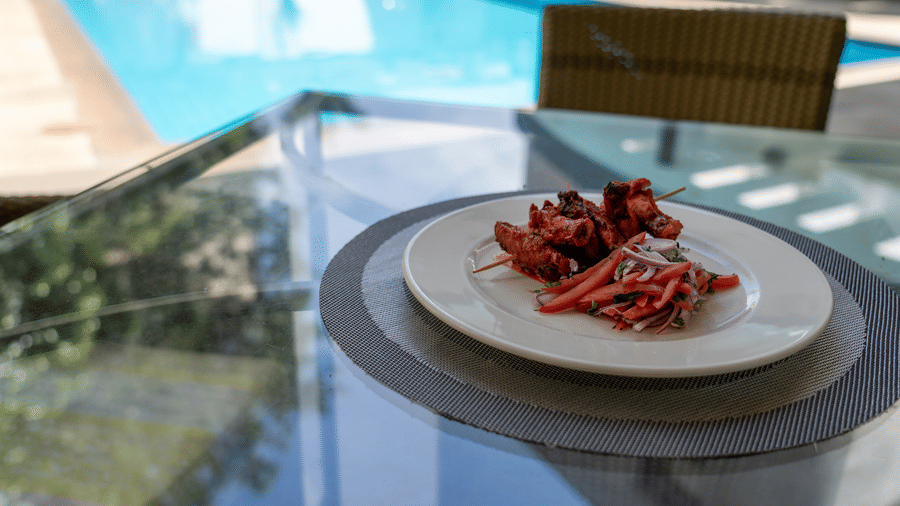 Appetiser plate placed on a glass table overlooking the swimming pool at The Zehneria, Nairobi