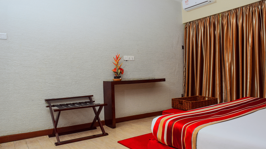 The bedroom of the Suite with bedside table and curtains at The Zehneria, Nairobi.
