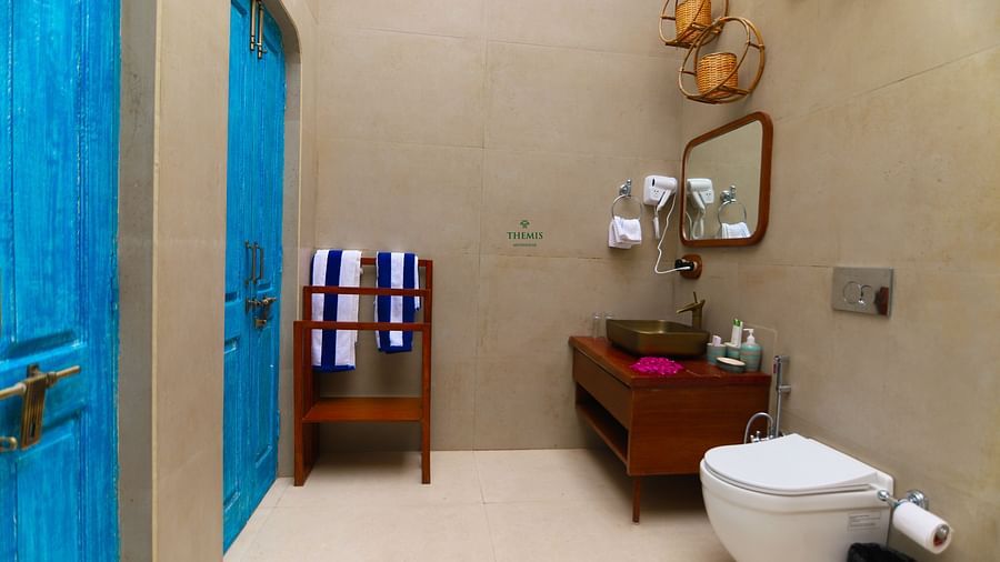 a view of a washroom decked with wooden sink and toiletries at Themis Mudhouse - A Nature's Retreat Resort & Wellness
