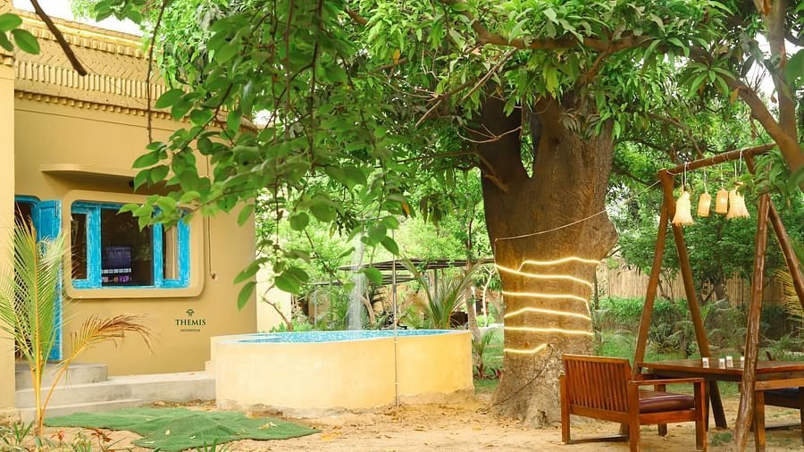 an outdoor seating arrangement beside a villa at Themis Mudhouse - A Nature's Retreat Resort & Wellness