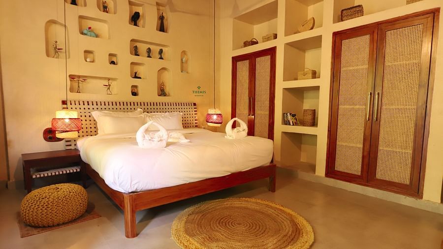 Royal Villas decked with a bed and rustic furnishing at Themis Mudhouse - A Nature's Retreat Resort & Wellness