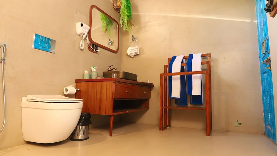 Washroom of Royal Villas decked with wooden sink, a looking glass and toiletries at Themis Mudhouse - A Nature's Retreat Resort & Wellness