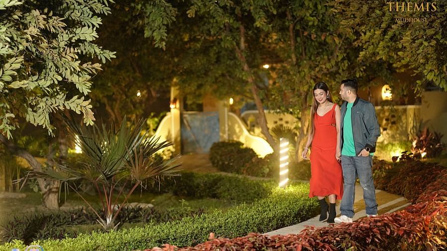 A couple walking in a garden at Themis Mudhouse - A Nature's Retreat Resort & Wellness