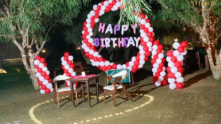 an image of a lawn decorated with balloons and happy birthday banners at Themis Mudhouse - A Nature's Retreat Resort & Wellness