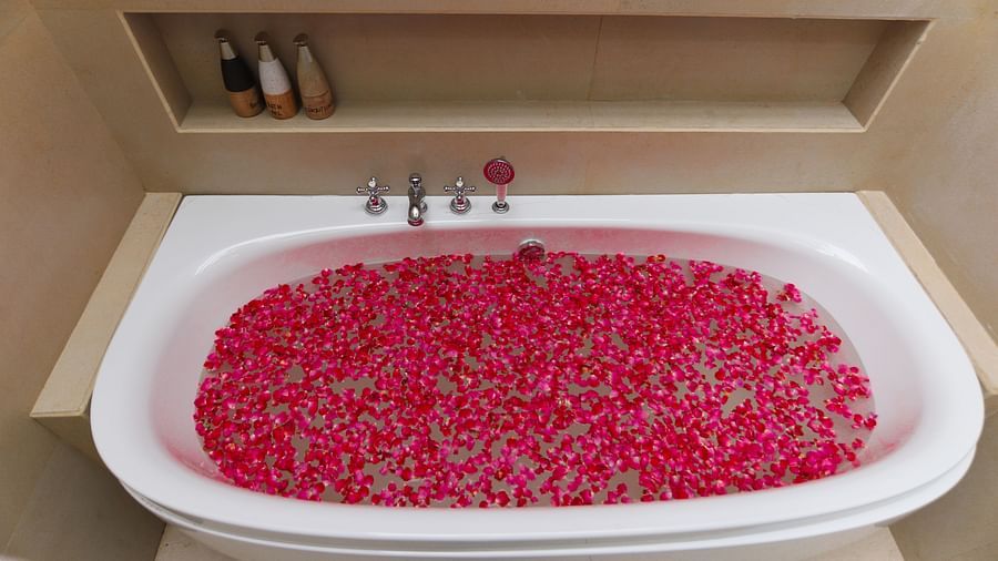 a bathtub filled with rose petals at Themis Mudhouse - A Nature's Retreat Resort & Wellness