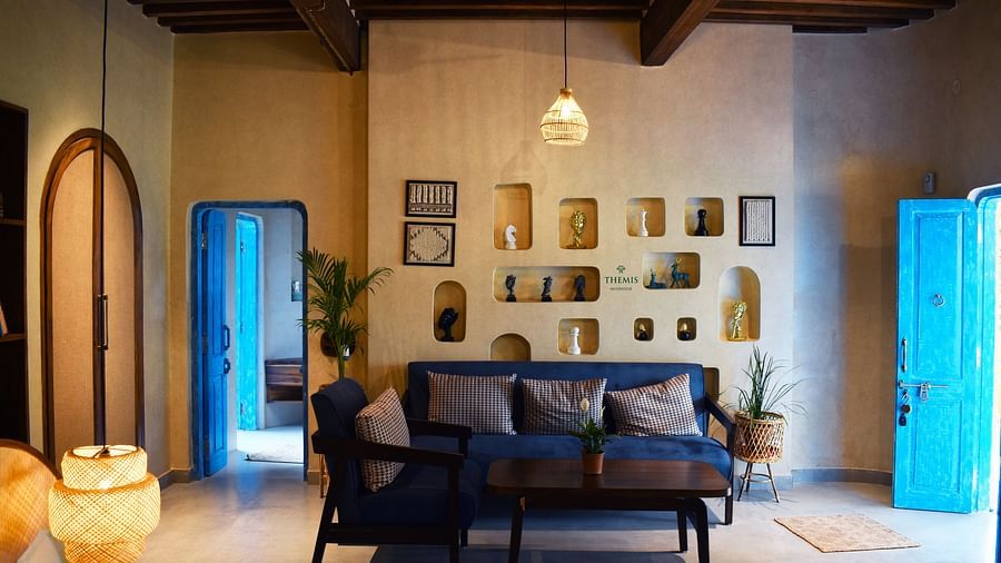 interior of Classic Villas arrayed with a sofa, trinkets and a lamp hanging from the ceiling at Themis Mudhouse - A Nature's Retreat Resort & Wellness