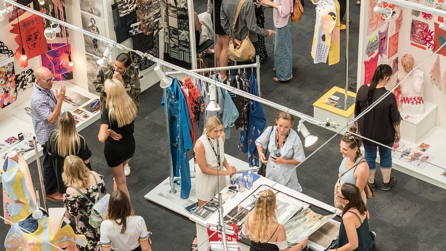 An aerial view of an Expo with many stalls and people mingling with each other.