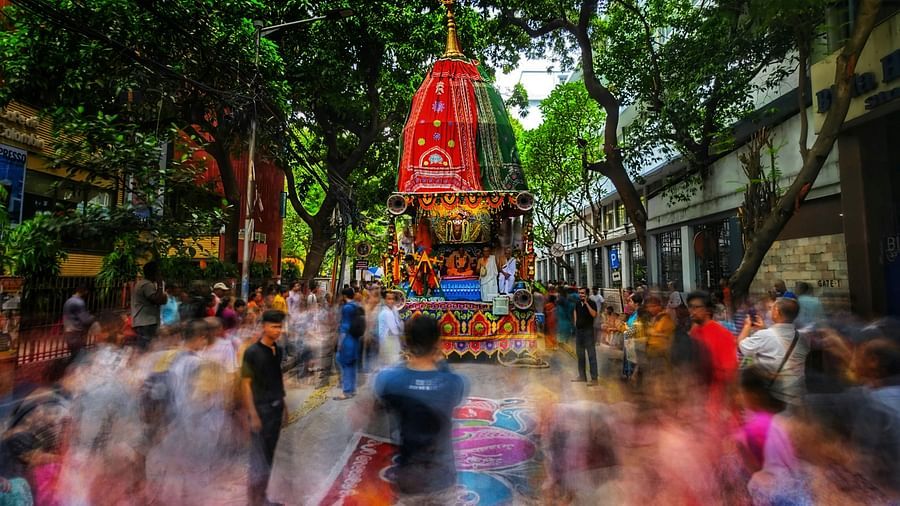 A crowd walking on the streets along a procession.