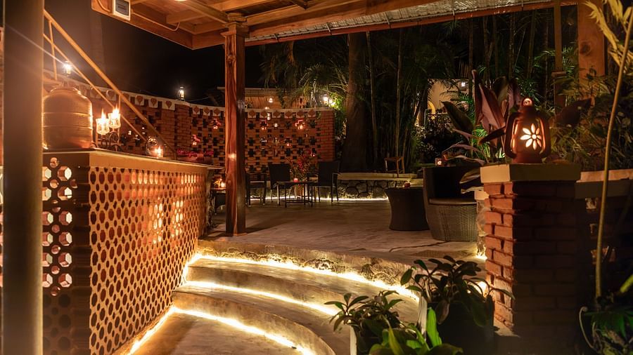 A night view of an entrance, with LED lights, chairs and small plants.