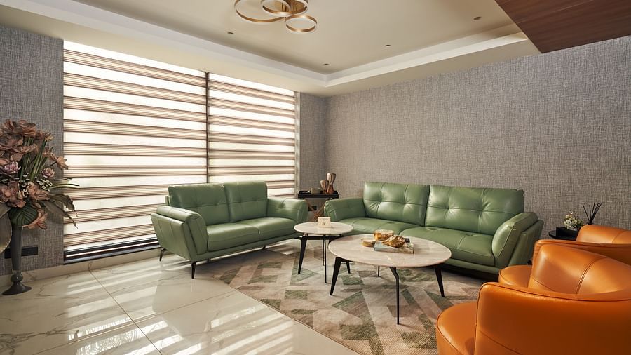 A beautiful designed seating area with multiple sofas seating up to 2 people, near a blinded window, at Triptam Hotel, Vrindavan