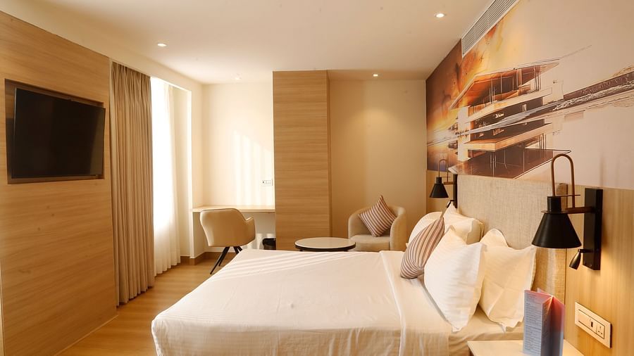 A well-designed suite in Zirakpur featuring a comfortable bed and seating area - Tulip Inn, Zirakpur