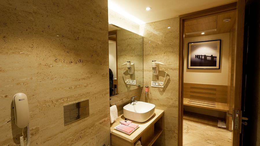 A modern bathroom with a vanity counter, a telephone, and toiletries - Tulip Inn, Zirakpur