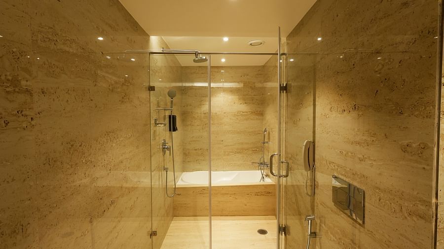 A bathroom in our suites with a shower area and bathtub separated by a glass partition - Tulip Inn, Zirakpur