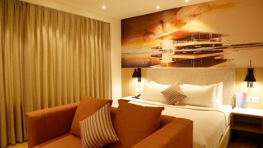 A suite with modern furniture, a large bed and a relaxing seating area - Tulip Inn, Zirakpur