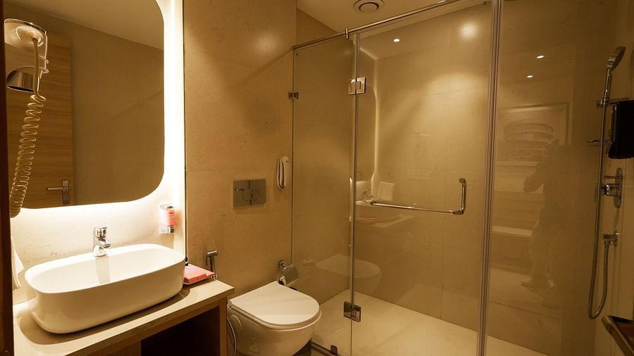 A washroom in our suites with a illuminated vanity counter and separate shower area - Tulip Inn, Zirakpur