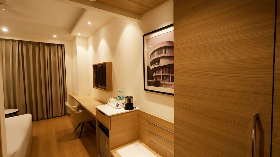An image of a hotel room in Zirakpur with a minibar, a cupboard, an electric kettle and a wall-mounted television - Tulip Inn, Zirakpur