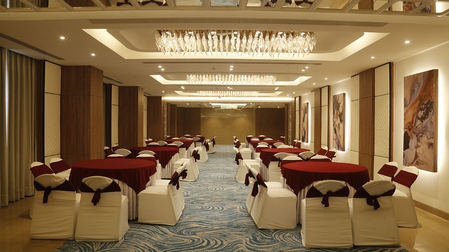 A spacious banquet hall with elegant interiors and chairs arranged in a theatre style seating - Tulip Inn, Zirakpur