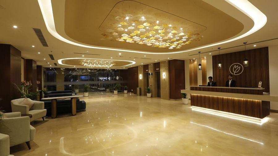 An image of a huge lobby featuring a reception desk where two people are sitting, and on the other side there are sofa sets for the guests - Tulip Inn, Zirakpur