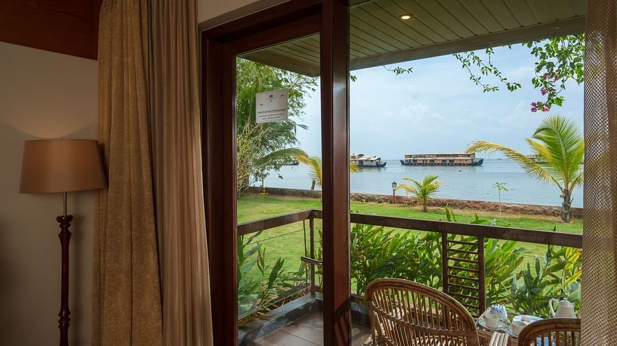 A view of the backwater with a couple of houseboats seen from the balcony of Lake View Premium Room at Uday Backwater Resort