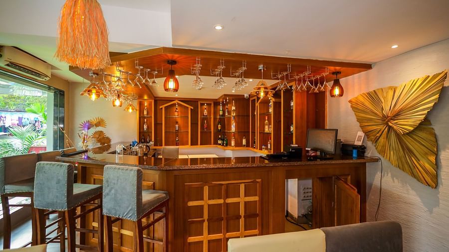 Cafe 24 with high seating chairs, wall decor, and wooden table counter at Vagator Downtown, Goa