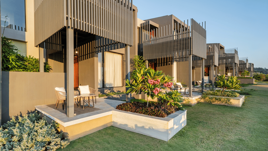 Ground-level guest units at Vandhara Sarovar Premiere, Patkote, featuring private patios with seating and direct access to a manicured lawn.