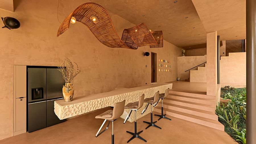 A stylish indoor bar area at Villa Moira by V Escapes, featuring natural textures, unique woven light fixtures, and modern bar stools.