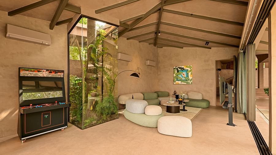 A bright, airy indoor living room at Villa Moira by V Escapes, featuring natural tones, comfortable seating, and integrated vertical greenery.