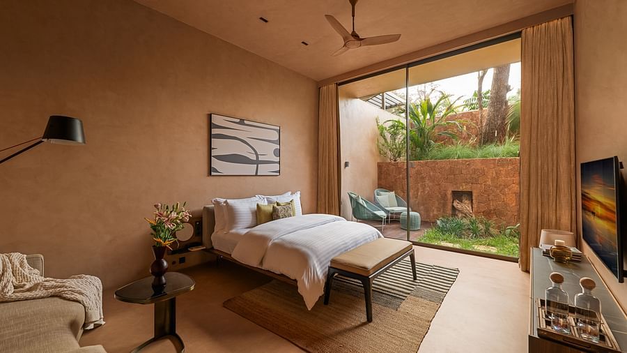 A spacious bedroom at Villa Moira by V Escapes, featuring a comfortable bed, subtle decor, and large sliding doors opening to an outdoor area.