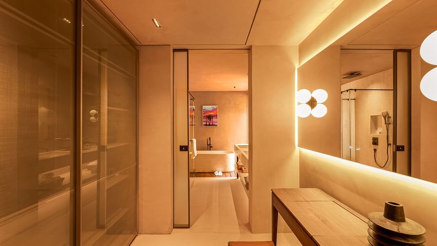 A sleek, modern hallway at Villa Moira by V Escapes, featuring warm lighting, a built-in bench, and minimalist decor.