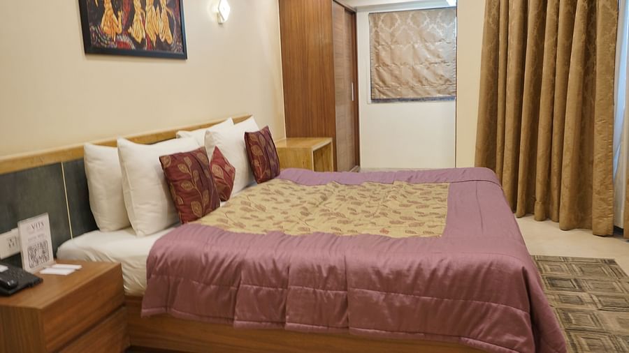 Double bedroom with bedside table and storage units at VITS Kamats Resort, Silvassa