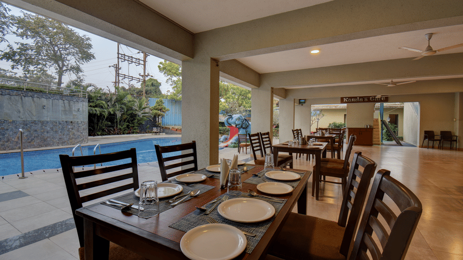 Indoor dining area with neatly arranged tables and poolside view at VITS Lonavala.