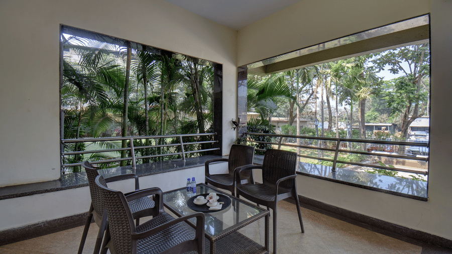Open-air balcony seating with garden and pool views at VITS Lonavala.