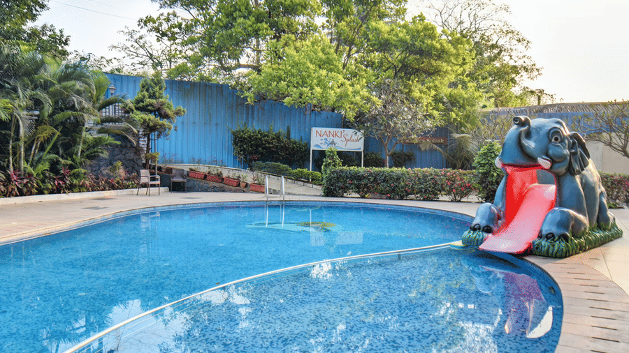 Outdoor swimming pool with playful water slide feature at VITS Lonavala.